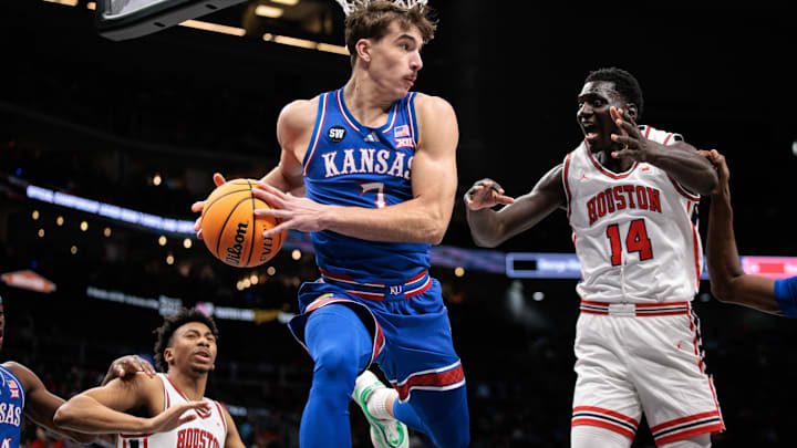 Mar 13, 2026; Kansas City, MO, USA; Kansas Jayhawks guard Kohl Rosario (7) rebounds around Houston Cougars forward Kalifa Sakho (14) during the second half at T-Mobile Center. Mandatory Credit: William Purnell-Imagn Images