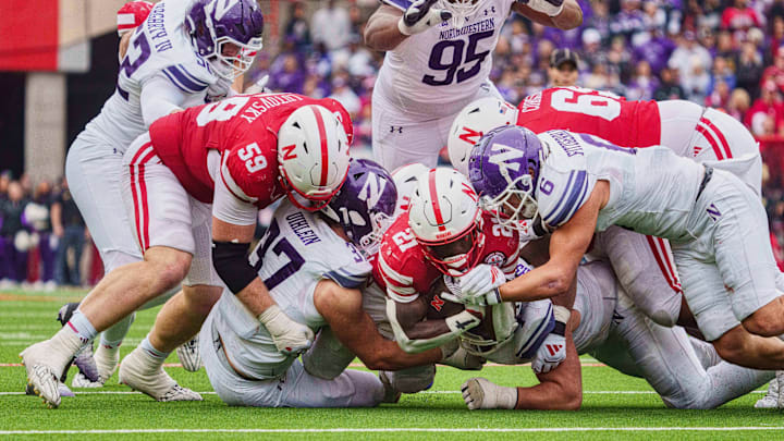 Oct 25, 2025; Lincoln, Nebraska, USA; Nebraska Cornhuskers running back Emmett Johnson (21) is tackled by Northwestern Wildcats defensive back Robert Fitzgerald (6) and linebacker Mac Uihlein (37) during the third quarter at Memorial Stadium. Mandatory Credit: Dylan Widger-Imagn Images Oct 25, 2025; Lincoln, Nebraska, USA; Nebraska Cornhuskers running back Emmett Johnson (21) is tackled by Northwestern Wildcats defensive back Robert Fitzgerald (6) and linebacker Mac Uihlein (37) during the third quarter at Memorial Stadium. Mandatory Credit: Dylan Widger-Imagn Images