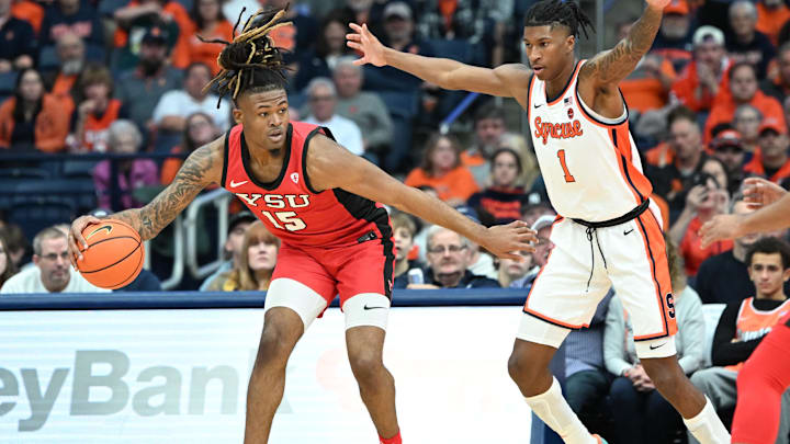 Nov 16, 2024; Syracuse, New York, USA; Youngstown State Penguins forward Cris Carroll (15) tries to move past Syracuse Orange forward Donnie Freeman (1) in the second half at the JMA Wireless Dome. Mandatory Credit: Mark Konezny-Imagn Images