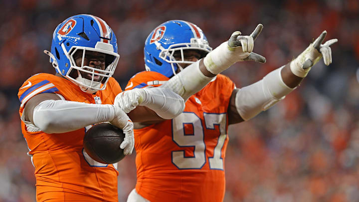 Denver Broncos defensive defensive end Sai'vion Jones (95) and defensive tackle Malcolm Roach (97) reacts after a fumble recovery during the second half at Empower Field at Mile High. 