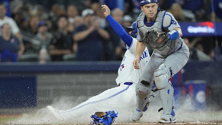 Nov 1, 2025; Toronto, Ontario, CAN; Toronto Blue Jays second baseman Isiah Kiner-Falefa (7) is out against Los Angeles Dodgers catcher Will Smith (16) in the ninth inning during game seven of the 2025 MLB World Series at Rogers Centre. Mandatory Credit: John E. Sokolowski-Imagn Images