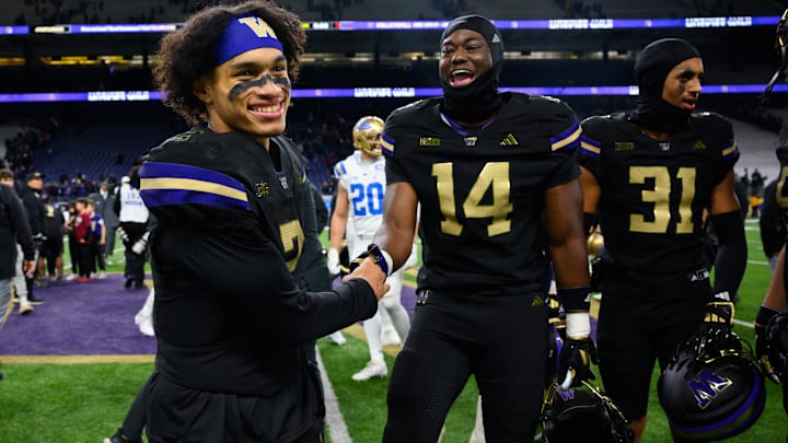  Huskies quarterback Demond Williams Jr. (2) and edge rusher Milton Hopkins Jr. (14) celebrate their 31-19 win over UCLA.