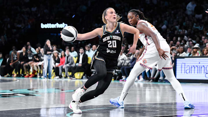 Jun 1, 2025; Brooklyn, New York, USA; New York Liberty guard Sabrina Ionescu (20) drives past Connecticut Sun center Tina Charles (31) during the second half at Barclays Center. Mandatory Credit: John Jones-Imagn Images