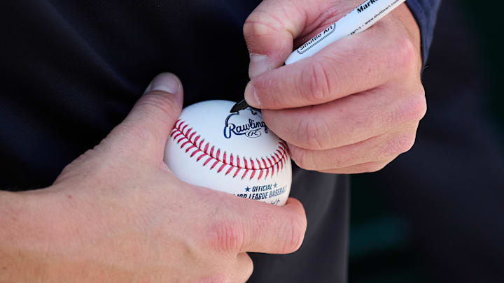 Mar 31, 2024; Oakland, California, USA; Cleveland Guardians outfielder Will Brennan (17) signs an autograph for a fan before the game against the Oakland Athletics at Oakland-Alameda County Coliseum. Mandatory Credit: Robert Edwards-Imagn Images