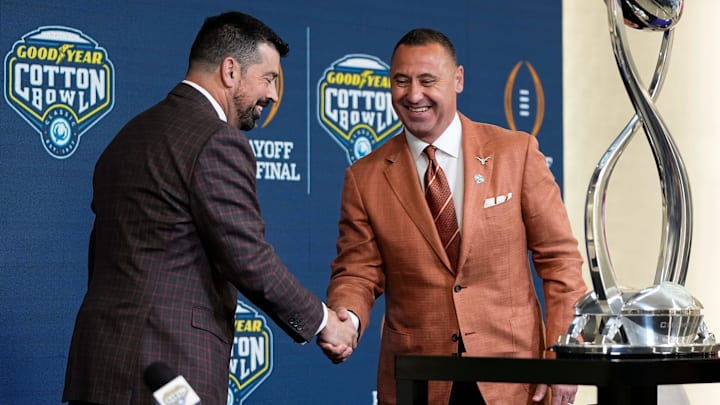 Ohio State Buckeyes head coach Ryan Day and Texas Longhorns head coach Steve Sarkisian shake hands following a press conference at AT&T Stadium prior to the College Football Playoff semifinal at the Cotton Bowl Classic in Arlington, Texas on Jan. 9, 2025.