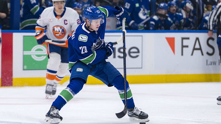 Nov 14, 2024; Vancouver, British Columbia, CAN; Vancouver Canucks forward Jonathan Lekkerimaki (23) handles the puck against the New York Islanders during the first period at Rogers Arena. Mandatory Credit: Bob Frid-Imagn Images
