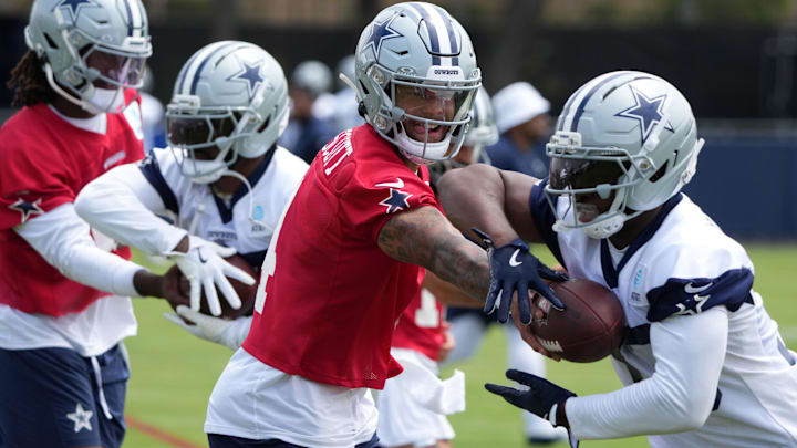 Dallas Cowboys quarterback Dak Prescott hands the ball off to running back Javonte Williams during training camp 