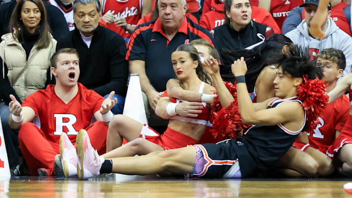 Xaivian Lee falls into the Rutgers Scarlet Knights cheerleaders during a game for Princeton.