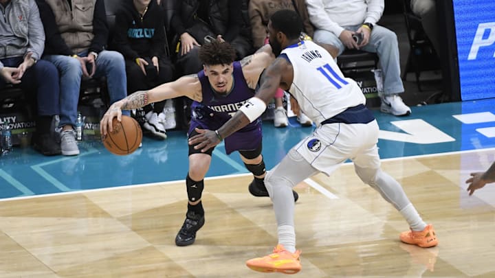 Charlotte Hornets guard LaMelo Ball drives past Dallas Mavericks guard Kyrie Irving during the first second at the Spectrum Center.