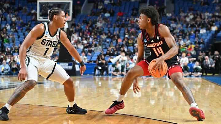 Mar 21, 2026; Buffalo, NY, USA; Louisville Cardinals guard Adrian Wooley (14) moves the ball against Michigan State Spartans guard Jeremy Fears Jr. (1) in the second half during a second round game of the men's 2026 NCAA Tournament at Keybank Center. Mandatory Credit: Mark Konezny-Imagn Images Mar 21, 2026; Buffalo, NY, USA; Louisville Cardinals guard Adrian Wooley (14) moves the ball against Michigan State Spartans guard Jeremy Fears Jr. (1) in the second half during a second round game of the men's 2026 NCAA Tournament at Keybank Center. Mandatory Credit: Mark Konezny-Imagn Images