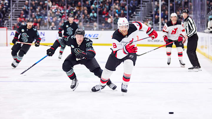 New Jersey Devils defenseman Johnathan Kovacevic (8) and Seattle Kraken center Berkly Catton (27) chase the puck: Blake Dahlin-Imagn Images