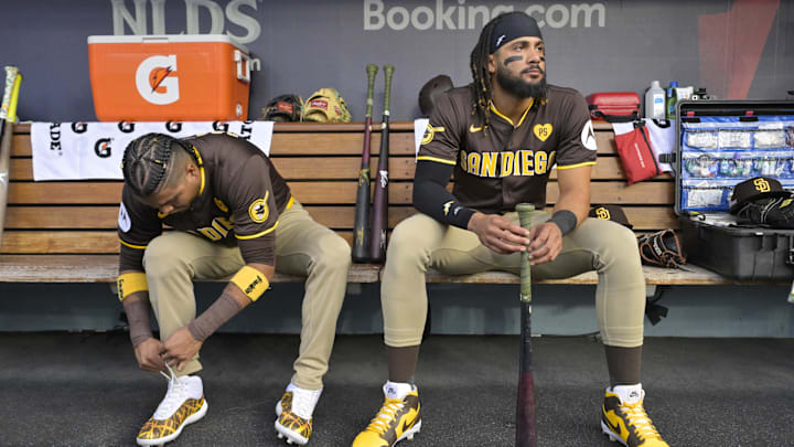 Oct 11, 2024; Los Angeles, California, USA; San Diego Padres first baseman Luis Arraez (4) and outfielder Fernando Tatis Jr. (23) look on in the dugout before game five against the Los Angeles Dodgers in the NLDS for the 2024 MLB Playoffs at Dodger Stadium. Mandatory Credit: Jayne Kamin-Oncea-Imagn Images