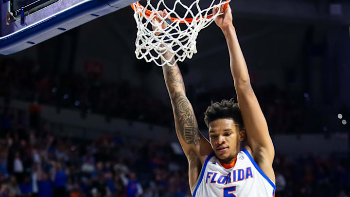 Florida Gators guard Will Richard (5) hangs on the basket after a slam dunk in the first half. The