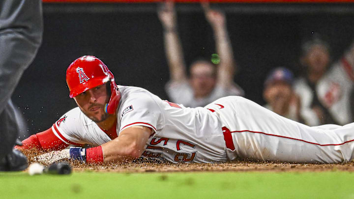 Sep 27, 2025; Anaheim, California, USA; Los Angeles Angels designated hitter Mike Trout (27) slides into home plate against Houston Astros catcher Yainer Diaz (21) during the sixth inning at Angel Stadium. Mandatory Credit: Jonathan Hui-Imagn Images