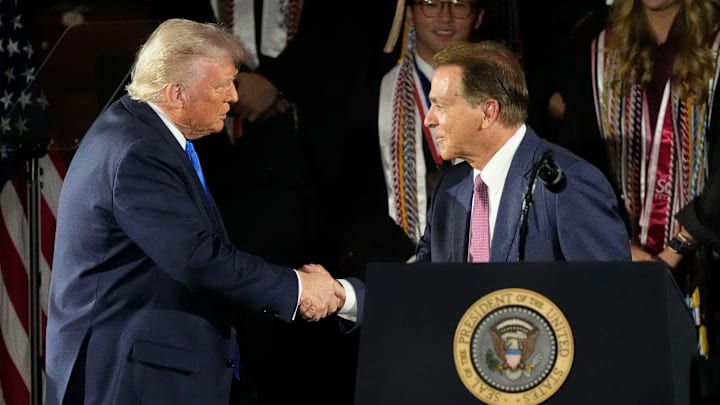 May 1, 2025; Tuscaloosa, AL, USA; President Donald Trump shakes hands with legendary Alabama football coach Nick Saban before delivering a special commencement address to University of Alabama graduates at Coleman Coliseum. Graduation occurs over the weekend. Mandatory Credit: Gary Cosby Jr.-Tuscaloosa News