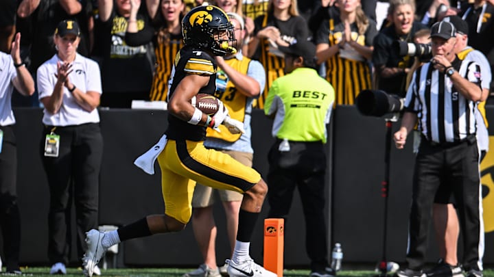 Oct 12, 2024; Iowa City, Iowa, USA; Iowa Hawkeyes defensive back John Nestor (7) scores on a touchdown pass from quarterback Cade McNamara (12) during the fourth quarter against the Washington Huskies at Kinnick Stadium. Mandatory Credit: Jeffrey Becker-Imagn Images