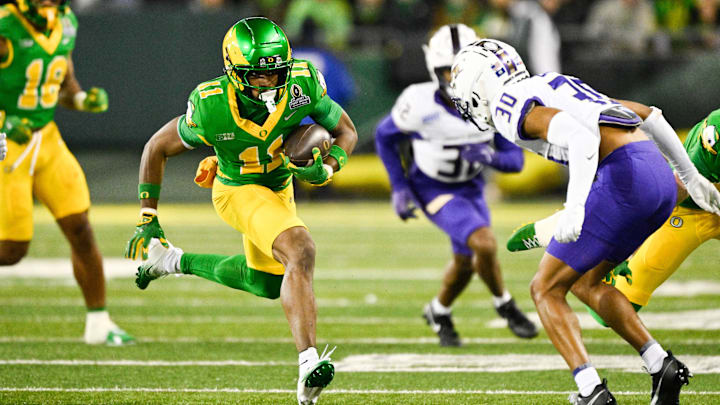 Dec 20, 2025; Eugene, OR, USA; Oregon Ducks wide receiver Jeremiah McClellan (11) runs after making a catch as James Madison Dukes cornerback Justin Eaglin (30) defends during the third quarter at Autzen Stadium. Mandatory Credit: Troy Wayrynen-Imagn Images