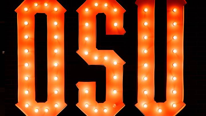 A lighted Oklahoma State logo in the lobby of an arena. A lighted Oklahoma State logo in the lobby of an arena.