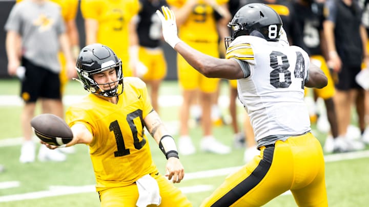 Aug 9, 2025; Iowa quarterback Jeremy Hecklinski (10) tries to get a pass off while getting pressure from Iowa defensive end Joseph Anderson (84) during the Hawkeyes Kids Day NCAA football open practice at Kinnick Stadium in Iowa City, Iowa. Mandatory Credit: Joseph Cress for the Des Moines Register