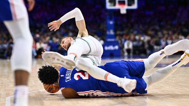 Nov 8, 2023; Philadelphia, Pennsylvania, USA; Boston Celtics center Kristaps Porzingis (8) falls over Philadelphia 76ers center Joel Embiid (21) in the third quarter at Wells Fargo Center. Mandatory Credit: Kyle Ross-Imagn Images