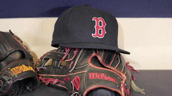 May 27, 2025; Milwaukee, Wisconsin, USA; A Boston Red Sox hat and glove sit in the dug out before a game against the Milwaukee Brewers at American Family Field. Mandatory Credit: Michael McLoone-Imagn Images