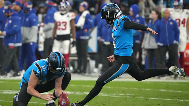 Nov 10, 2024; Munich, Germany; Carolina Panthers place kicker Eddy Pineiro (4) kicks an extra point out of the hold of punter Johnny Hekker (10) against the New York Giants in the second half during the 2024 NFL Munich Game at Allianz Arena. Mandatory Credit: Kirby Lee-Imagn Images