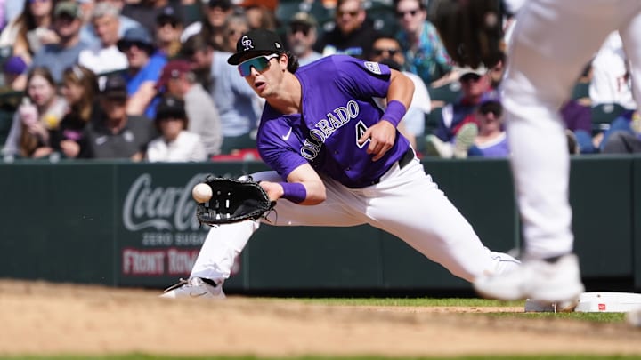 Apr 26, 2025; Denver, Colorado, USA; Colorado Rockies first base Michael Toglia (4) fields the ball in the sixth inning against the Cincinnati Reds at Coors Field. Mandatory Credit: Ron Chenoy-Imagn Images