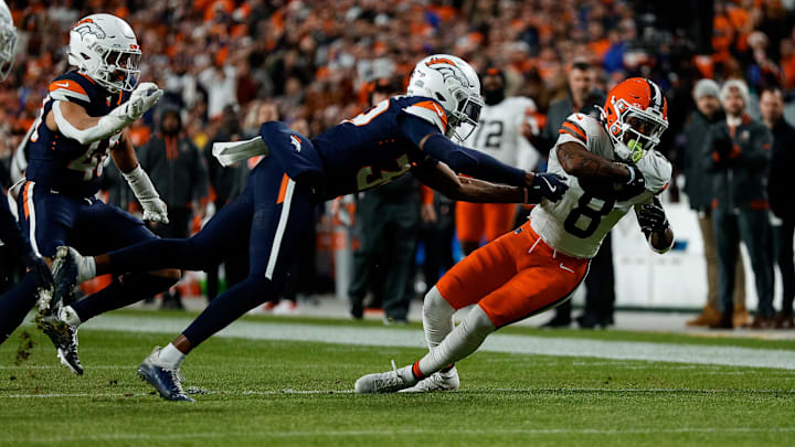 Dec 2, 2024; Denver, Colorado, USA; Cleveland Browns wide receiver Elijah Moore (8)r reaches for extra yards against Denver Broncos cornerback Levi Wallace (39) in the first quarter at Empower Field at Mile High. 