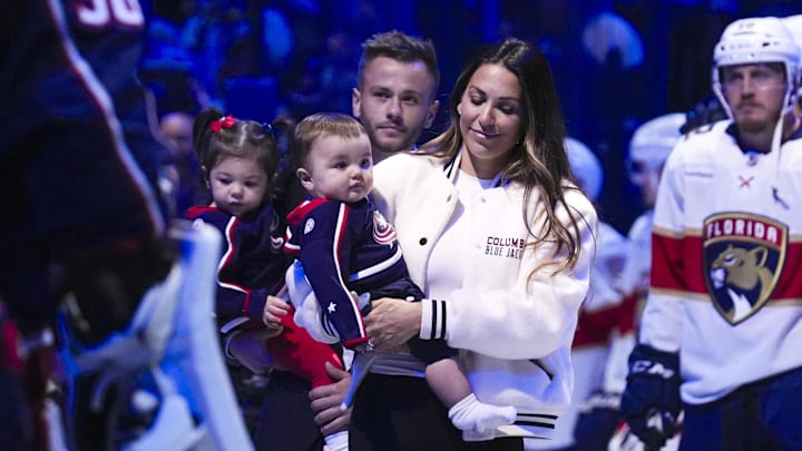 Johnny Gaudreau's wife Meredith walks out onto the ice with her children for a memorial for Johnny and Matthew Gaudreau.