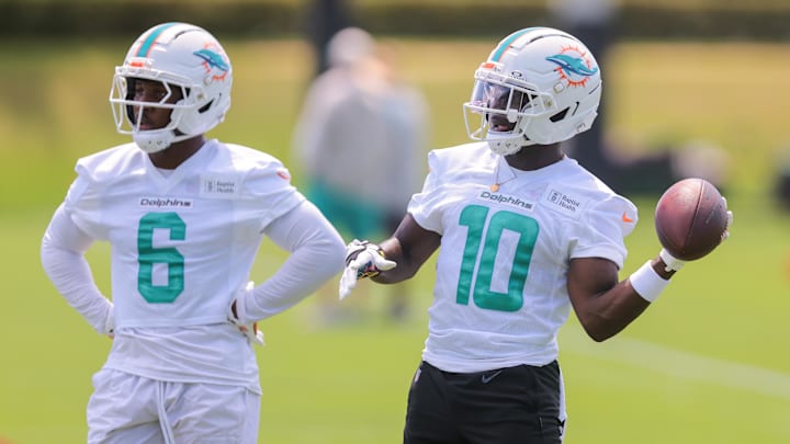 Jun 10, 2025; Miami, FL, USA; Miami Dolphins wide receiver Tyreek Hill (10) tosses a football as wide receiver Malik Washington (6) looks on during mandatory minicamp at Hard Rock Stadium. Mandatory Credit: Sam Navarro-Imagn Images
