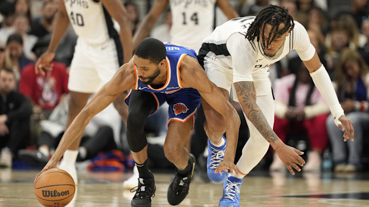 Mar 19, 2025; San Antonio, Texas, USA; New York Knicks forward Mikal Bridges (25) and San Antonio Spurs guard Stephon Castle (5) battle for a loose ball during the first half at Frost Bank Center. Mandatory Credit: Scott Wachter-Imagn Images