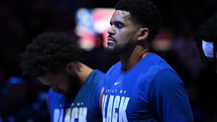 Feb 3, 2026; Detroit, Michigan, USA;  Detroit Pistons forward Tobias Harris (12) and Detroit Pistons guard Cade Cunningham (2) stand at attention for the National Anthem before their game against the Denver Nuggets at Little Caesars Arena.