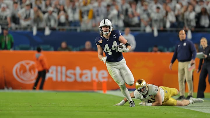 Jan 9, 2025; Miami, FL, USA; Penn State Nittany Lions tight end Tyler Warren (44) runs passed Notre Dame Fighting Irish defensive lineman Donovan Hinish (41) in the first half in the Orange Bowl at Hard Rock Stadium. Mandatory Credit: Sam Navarro-Imagn Images