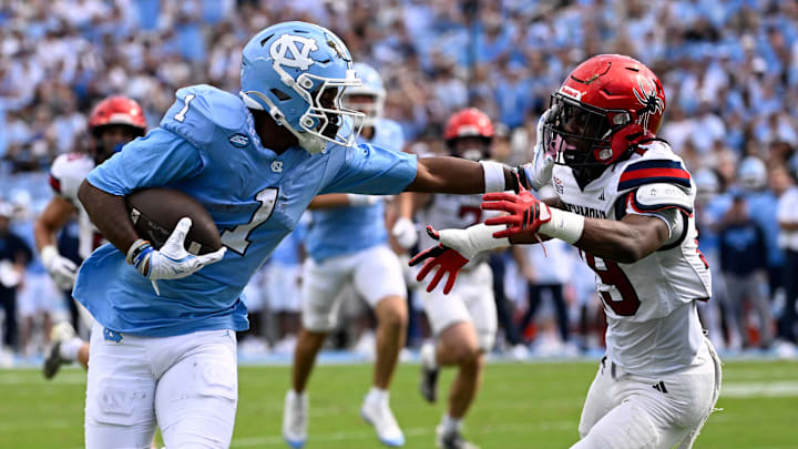 Sep 13, 2025; Chapel Hill, North Carolina, USA; North Carolina Tar Heels wide receiver Jordan Shipp (1) scores a touchdown as Richmond Spiders defensive back Lee Bruner IV (19) defends in the first quarter at Kenan Stadium. Mandatory Credit: Bob Donnan-Imagn Images
