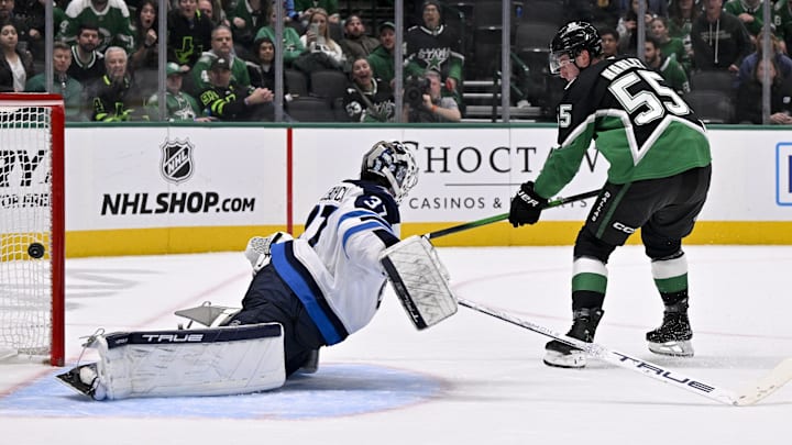 Feb 2, 2026; Dallas, Texas, USA; Dallas Stars defenseman Thomas Harley (55) scores the game winning goal against Winnipeg Jets goaltender Connor Hellebuyck (37) during the overtime period at the American Airlines Center. Mandatory Credit: Jerome Miron-Imagn Images