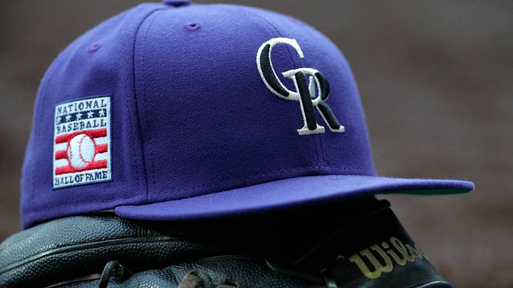 Colorado Rockies hat on top of a glove Colorado Rockies hat on top of a glove