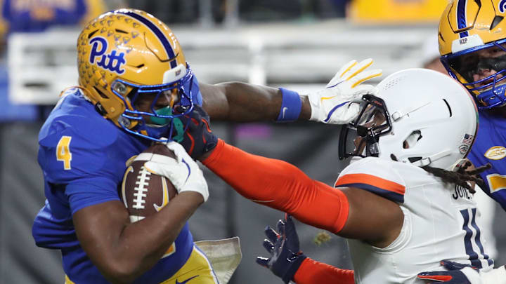 Nov 9, 2024; Pittsburgh, Pennsylvania, USA;  Pittsburgh Panthers running back Daniel Carter (4) carries the ball against Virginia Cavaliers defensive end Mekhi Buchanan (11) during the second quarter at Acrisure Stadium. Mandatory Credit: Charles LeClaire-Imagn Images