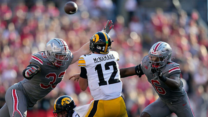 Oct 5, 2024; Columbus, OH, USA; Iowa Hawkeyes quarterback Cade McNamara (12) gets a pass off against Ohio State Buckeyes defensive end Jack Sawyer (33) and Ohio State Buckeyes safety Sonny Styles (6) in the second quarter during the NCAA football game at Ohio Stadium.