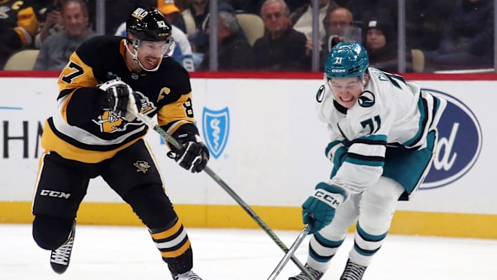 Nov 16, 2024; Pittsburgh, Pennsylvania, USA;  Pittsburgh Penguins center Sidney Crosby (87) and San Jose Sharks center Macklin Celebrini (71) battle to control the puck during the third period at PPG Paints Arena. Mandatory Credit: Charles LeClaire-Imagn Images