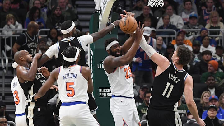 Apr 7, 2024; Milwaukee, Wisconsin, USA; New York Knicks center Mitchell Robinson (23) battles for a loose ball with m9/ and Milwaukee Bucks center Brook Lopez (11) in the first half at Fiserv Forum. Mandatory Credit: Michael McLoone-Imagn Images