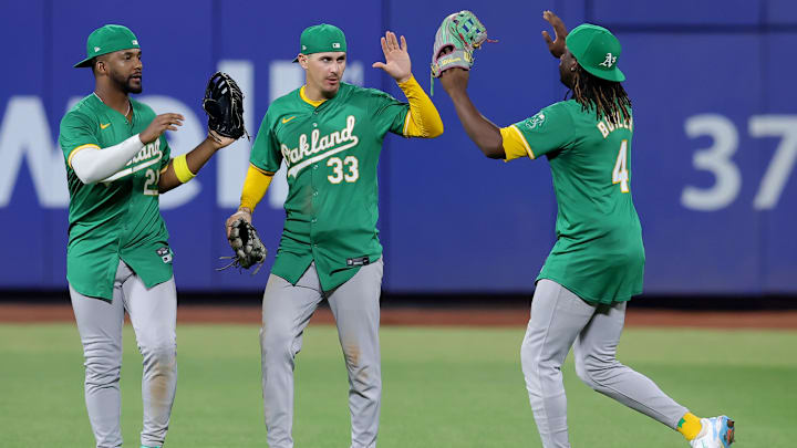 Aug 13, 2024; New York City, New York, USA; Oakland Athletics left fielder Miguel Andujar (22) and center fielder JJ Bleday (33) and right fielder Lawrence Butler (4) celebrate after defeating the New York Mets at Citi Field. Mandatory Credit: Brad Penner-Imagn Images