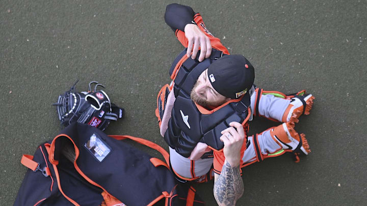 Feb 10, 2026; Scottsdale, AZ, USA;  San Francisco Giants  catcher Eric Haase (18) puts on equiment during a Spring Training workout at Scottsdale Stadium Mandatory Credit: Matt Kartozian-Imagn Images