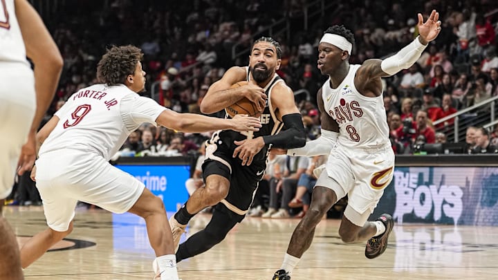 Apr 10, 2026; Atlanta, Georgia, USA; Atlanta Hawks guard Gabe Vincent (4) tries to go between Cleveland Cavaliers guards Craig Porter Jr. (9) and Dennis Schroder (8) during the first half at State Farm Arena. Mandatory Credit: Dale Zanine-Imagn Images