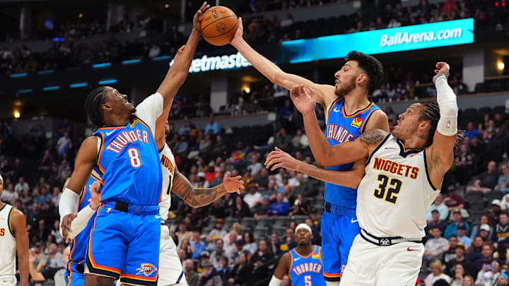 Oct 15, 2024; Denver, Colorado, USA; Denver Nuggets forward Michael Porter Jr. (1) and forward Aaron Gordon (32) and Oklahoma City Thunder forward Chet Holmgren (7) and forward Jalen Williams (8) reach for the ball in the second quarter at Ball Arena. Mandatory Credit: Ron Chenoy-Imagn Images