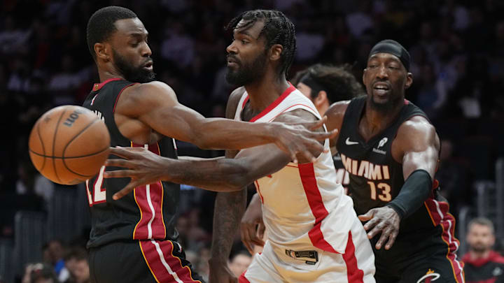 Mar 21, 2025; Miami, Florida, USA;  Houston Rockets forward Tari Eason (17) passes around Miami Heat forward Andrew Wiggins (22) as center Bam Adebayo (13) closes in during the first half at Kaseya Center. Mandatory Credit: Jim Rassol-Imagn Images