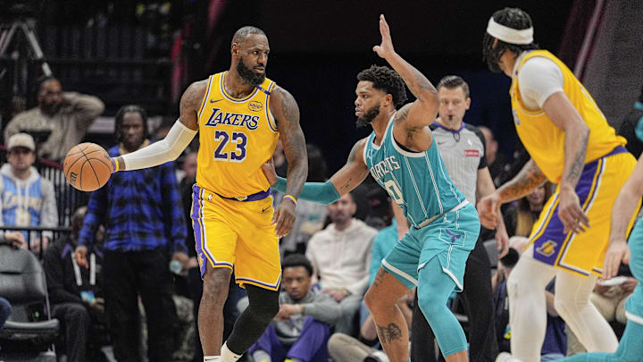 Jan 27, 2025; Charlotte, North Carolina, USA; Los Angeles Lakers forward LeBron James (23) handles the ball guarded by Charlotte Hornets forward Miles Bridges (0) during the second half at the Spectrum Center. Mandatory Credit: Jim Dedmon-Imagn Images