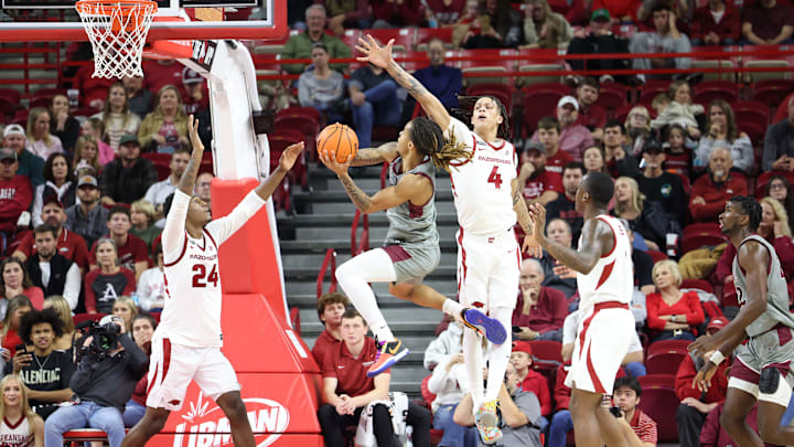 Nov 25, 2024; Fayetteville, Arkansas, USA; Arkansas Razorbacks forwards Trevon Brazile (4) and Billy Richmond III (24) defend a shot by Maryland Eastern Shore Hawks guard Ketron “KC” Shaw (0) during the second half at Bud Walton Arena. Arkansas won 109-35. Mandatory Credit: Nelson Chenault-Imagn Images