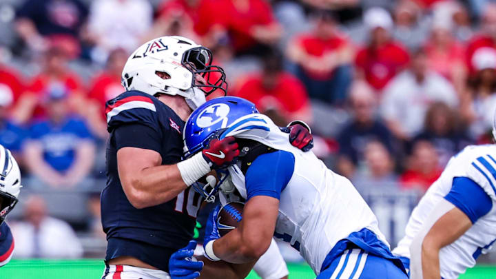Oct 11, 2025; Tucson, Arizona, USA; Arizona Wildcats linebacker Carter Jones (18) throws down Brigham Young Cougars running back LJ Martin (4) during the first quarter of the game at Arizona Stadium. Mandatory Credit: Aryanna Frank-Imagn Images Oct 11, 2025; Tucson, Arizona, USA; Arizona Wildcats linebacker Carter Jones (18) throws down Brigham Young Cougars running back LJ Martin (4) during the first quarter of the game at Arizona Stadium. Mandatory Credit: Aryanna Frank-Imagn Images