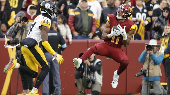 Nov 10, 2024; Landover, Maryland, USA; Washington Commanders safety Jeremy Chinn (11) intercepts a pass intended for Pittsburgh Steelers wide receiver George Pickens (14) during the second half at Northwest Stadium. Mandatory Credit: Amber Searls-Imagn Images