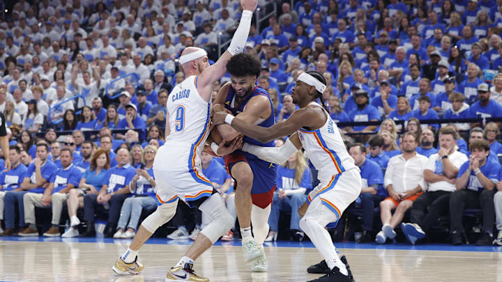 May 13, 2025; Oklahoma City, Oklahoma, USA; Denver Nuggets guard Jamal Murray (27) drives between Oklahoma City Thunder guard Alex Caruso (9) and guard Shai Gilgeous-Alexander (2) during the second quarter of game five of the second round for the 2025 NBA Playoffs at Paycom Center. Mandatory Credit: Alonzo Adams-Imagn Images May 13, 2025; Oklahoma City, Oklahoma, USA; Denver Nuggets guard Jamal Murray (27) drives between Oklahoma City Thunder guard Alex Caruso (9) and guard Shai Gilgeous-Alexander (2) during the second quarter of game five of the second round for the 2025 NBA Playoffs at Paycom Center. Mandatory Credit: Alonzo Adams-Imagn Images